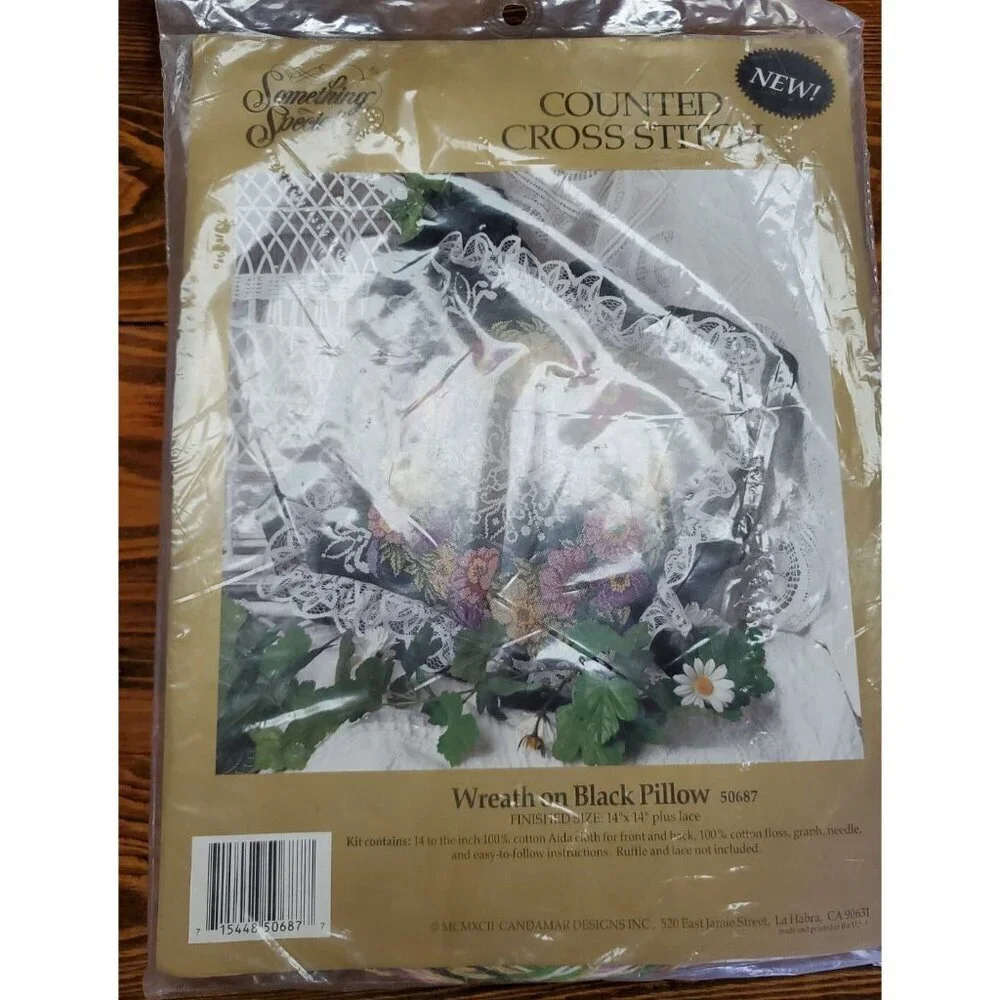 Something Special Counted Cross Stitch Kit #50687 wreath on black pillow.
